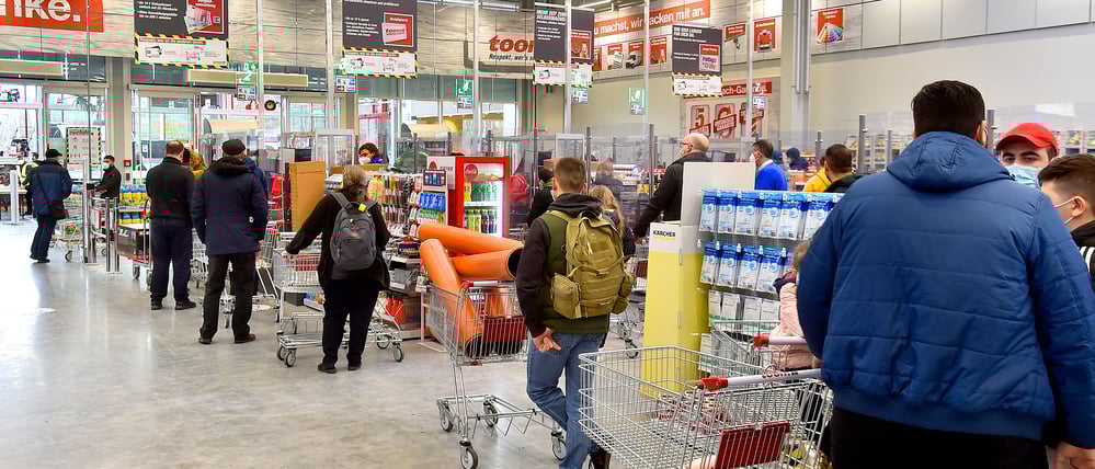 Lange Schlangen an den Kassen eines Baumarkts.