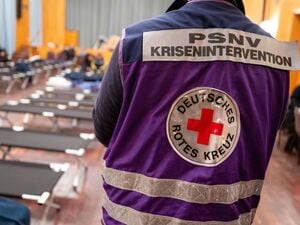 Ein Mitarbeiter vom Deutschen Roten Kreuz (DRK) steht im Bürgersaal vom Bezirksamt Zehlendorf, in dem Feldbetten aufgebaut sind. 