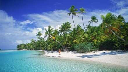 Eine Frau geht am Sandstrand von Aitutaki entlang, einer der Cookinseln (undatiertes Archivbild).