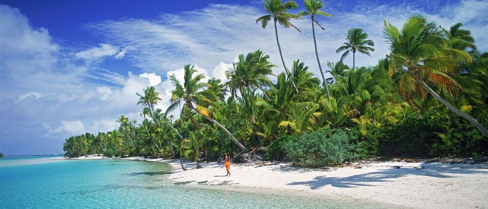 Eine Frau geht am Sandstrand von Aitutaki entlang, einer der Cookinseln (undatiertes Archivbild).