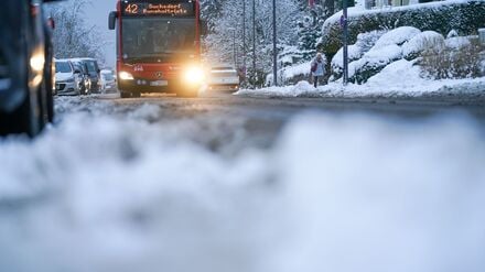 Ein Bus der Kieler Verkehrsgesellschaft (KVG) fährt im winterlichen Kiel auf einer Straße. 