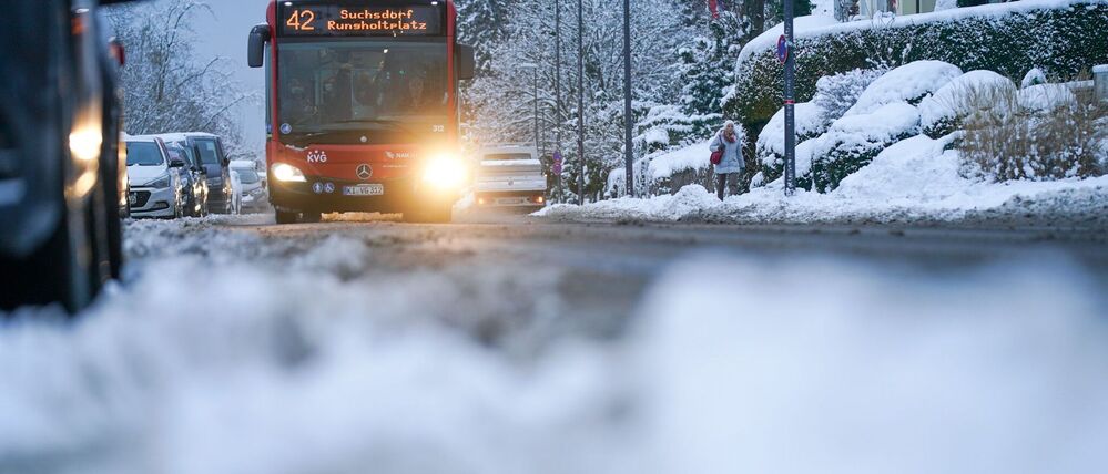 Ein Bus der Kieler Verkehrsgesellschaft (KVG) fährt im winterlichen Kiel auf einer Straße. 