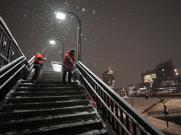 06.01.2026, Hamburg: Mitarbeiter streuen die Treppenstufen an der U-Bahnstation Baumwall im Hamburger Hafen. Foto: Marcus Brandt/dpa +++ dpa-Bildfunk +++
OhWehSchnee