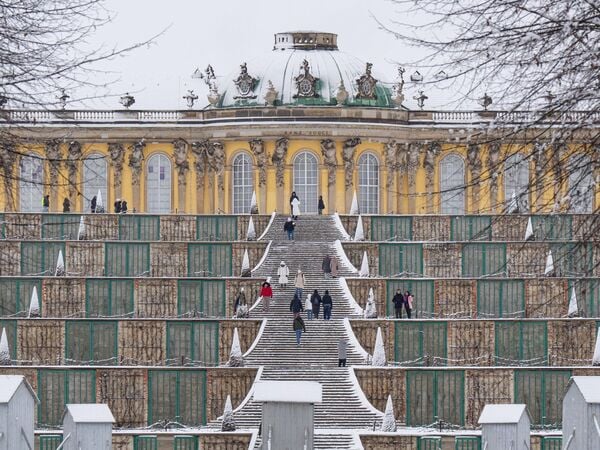 ARCHIV - 03.01.2026, Brandenburg, Potsdam: Menschen gehen vor der verschneiten Kulisse des Schloss Sanssouci in Potsdam spazieren. (zu dpa: «SPSG stellt mögliche Schließung von Parks in Aussicht») Foto: Georg Moritz/dpa +++ dpa-Bildfunk +++
