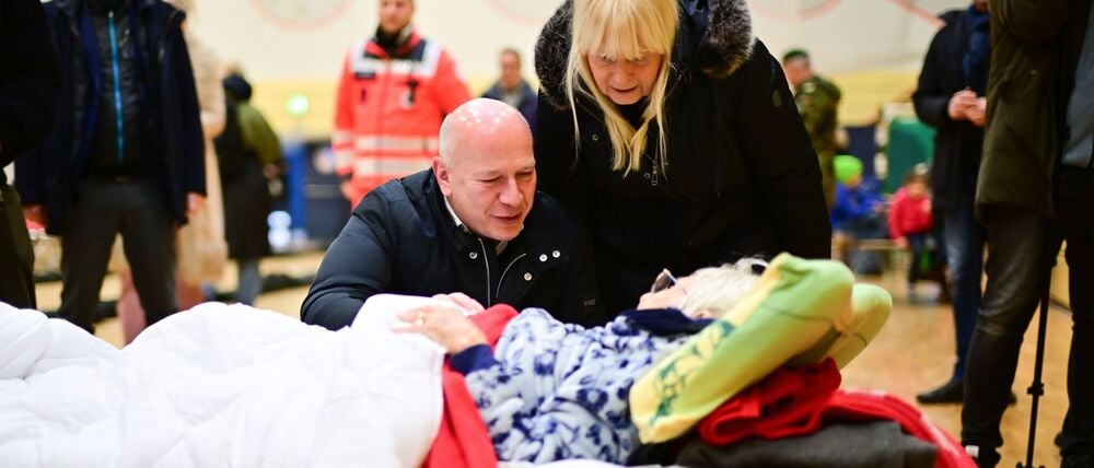 Kai Wegner (CDU), Regierender Bürgermeister von Berlin, und Iris Spranger (SPD), Berliner Senatorin für Inneres und Sport, sprechen während eines Stromausfalls im Südwesten Berlins in einer Notunterkunft mit der 97-jährigen Ingeborg aus Lichtenfelde. 