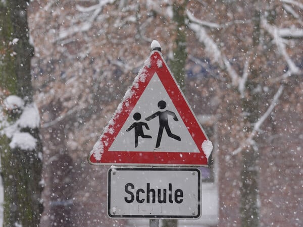 Schnee liegt auf einem Verkehrsschild und Hinweisschild mit der Aufschrift „Schule“ vor einer Schule im Stadtteil St. Georg. Die Schulen in Hamburg bleiben wegen der Witterungsverhältnisse und des erwarteten starken Schneefalls am Freitag geschlossen. Das teilte die Schulbehörde mit. +++ dpa-Bildfunk +++