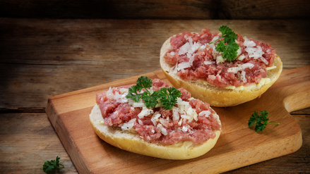 Ein Mettbrötchen mit rohem Hackfleisch. 