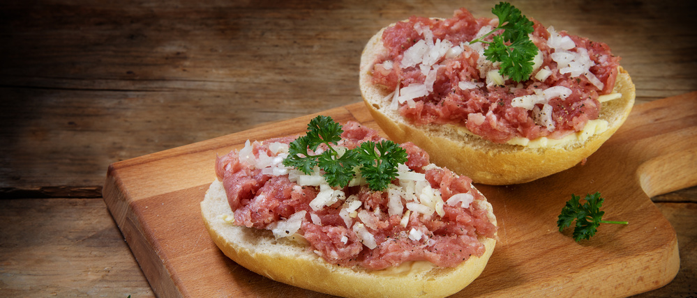 Ein Mettbrötchen mit rohem Hackfleisch. 
