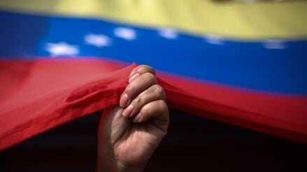 Eine Frau hält eine Fahne von Venezuela (Symbolfoto).