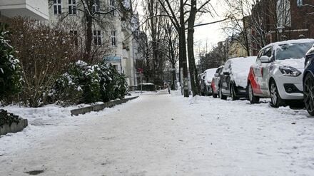 Ein Fußgängerweg in einem Wohngebiet ist nicht geräumt. Es besteht Rutschgefahr.