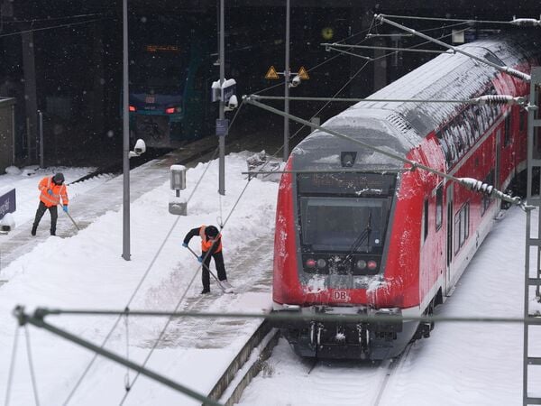 dpatopbilder - 08.01.2026, Hamburg: Mitarbeiter beseitigen die zentimeterdicke Schneeschicht auf den Bahnsteigen im Hamburger Hauptbahnhof. Foto: Marcus Brandt/dpa +++ dpa-Bildfunk +++