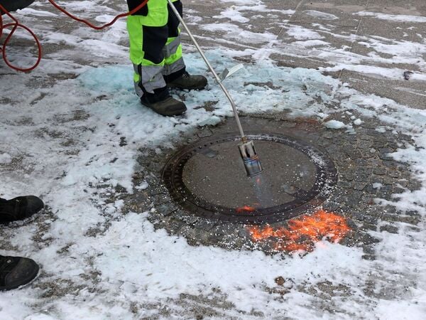 08.01.2026, Mecklenburg-Vorpommern, Rerik: Im Hafen am Salzhaff werden die eingefrorenen Schachtdeckel mit einem Gasbrenner freigelegt, um sie im Bedarfsfall öffnen zu können. Der Winter hat Norddeutschland fest im Griff. Foto: Bernd Wüstneck/dpa +++ dpa-Bildfunk +++