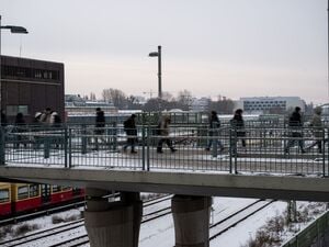 Menschen gehen über eine Brücke in der Nähe vom Bahnhof Warschauer Straße. 