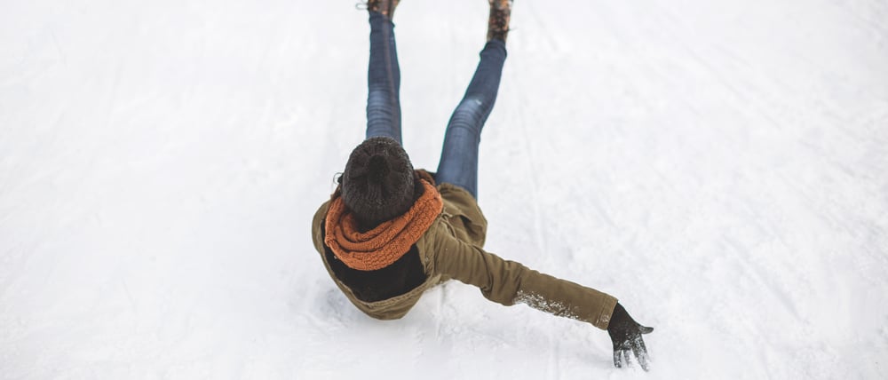 Eine junge Frau rutscht einen vereisten Hang hinunter (Symbolbild).