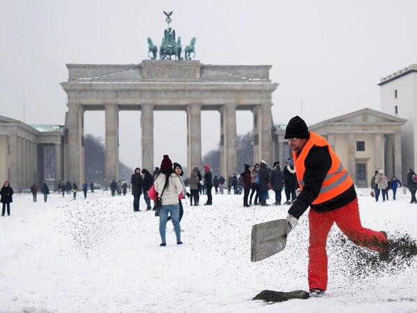 Ein Mitarbeiter der Berliner Stadtreinigung (BSR) verteilt Granulat vor dem Brandenburger Tor am 06.01.2015 in Berlin. Nach Schneefall ist es im Straßenverkehr zu einigen Behinderungen gekommen. Foto: Jörg Carstensen/dpa ++ +++ dpa-Bildfunk +++
