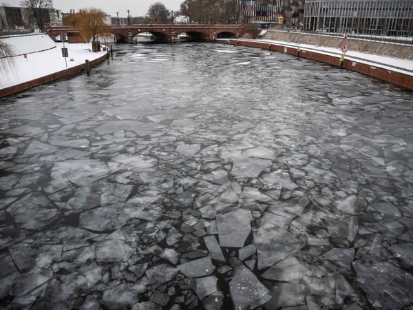 Sheets of ice form in the river Spree in front of Berlin's central railway station on January 9, 2026. Storm Elli has arrived in northern Germany with heavy winds and snow. (Photo by John MACDOUGALL / AFP)
