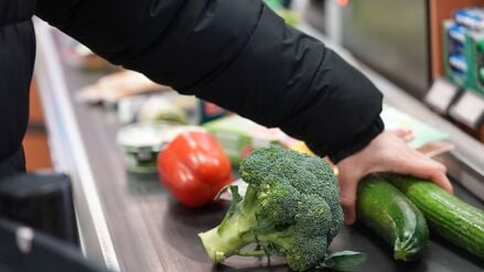 Ein Mann legt seinen Einkauf auf das Laufband an einer Kasse in einem Supermarkt (Symbolbild).