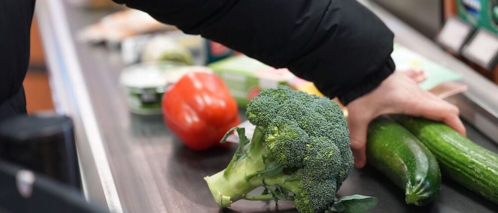 Ein Mann legt seinen Einkauf auf das Laufband an einer Kasse in einem Supermarkt (Symbolbild).