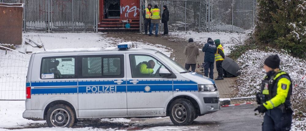 Einsatzkräfte der Polizei stehen an der Brandstelle der Kabelbrücke vor dem Kraftwerk Lichterfelde am Teltowkanal.