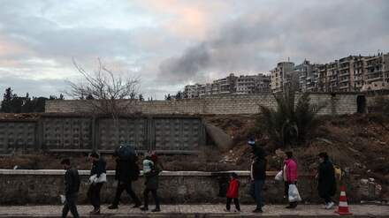 Residents carrying their belongings leave Aleppo's Kurdish-majority Sheikh Maqsud neighbourhood on January 10, 2026, after days of deadly clashes between Kurdish fighters and security forces. Syrian authorities on January 10 began transferring Kurdish fighters from Aleppo's Sheikh Maqsud neighbourhood to the country's northeast, state television reported. (Photo by OMAR HAJ KADOUR / AFP)