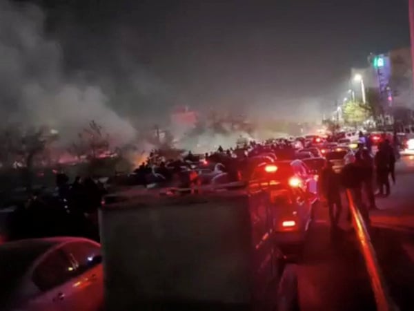 Smoke rises as protesters gather amid evolving anti-government unrest in Mashhad, Razavi Khorasan province, Iran, released on January 10, 2026, in this screen grab obtained from a social media video. SOCIAL MEDIA/via REUTERS  THIS IMAGE HAS BEEN SUPPLIED BY A THIRD PARTY. MANDATORY CREDIT. NO RESALES. NO ARCHIVES. Verification lines: Reuters was able to confirm the location from buildings, traffic signboard and overbridge which matched with file and satellite imagery. Date of the video could not be verified. However, several corroborating videos uploaded on social media showed similar scenes along Vakil Abad highway in Mashhad.