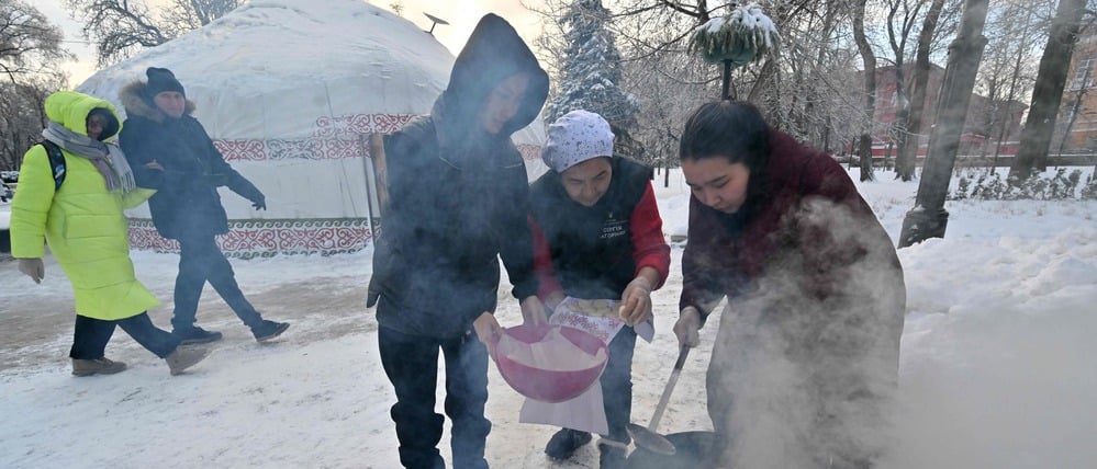 Freiwillige kochen nach den massiven russischen Luftangriffen und Stromausfällen im Freien.