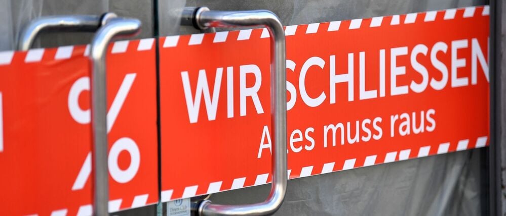 „Wir schliessen. Alles muss raus“ steht auf dem Banner in der Tür eines Geschäfts in der Erfurter Altstadt (Symbolbild).