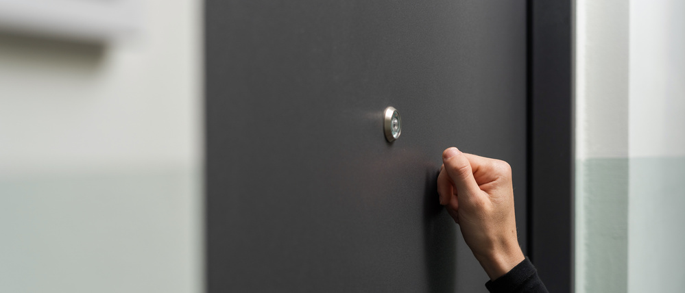 Eine Frau klopft an eine Wohnungstür (Symbolbild)