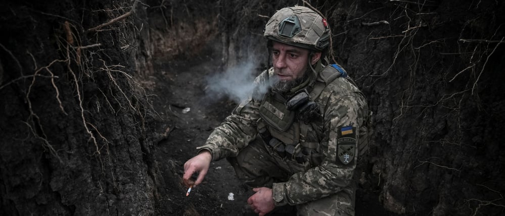 Ein Artillerist der 44. Separaten Artilleriebrigade der ukrainischen Streitkräfte, benannt nach Hetman Danylo Apostol, raucht in einem Schützengraben vor einem Feuerangriff auf russische Truppen.