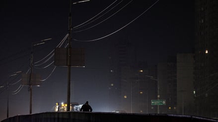 A resident walks along a dark street during a power blackout after critical civil infrastructure was hit by recent Russian missile and drone strikes, amid Russia's attack on Ukraine, in Kyiv, Ukraine, January 12, 2026. REUTERS/Valentyn Ogirenko