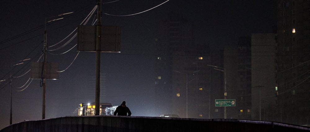 A resident walks along a dark street during a power blackout after critical civil infrastructure was hit by recent Russian missile and drone strikes, amid Russia's attack on Ukraine, in Kyiv, Ukraine, January 12, 2026. REUTERS/Valentyn Ogirenko