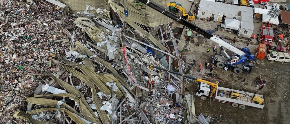 Die Einsatzkräfte suchen unter anderem mit einem Kran in den Abfall-Massen.