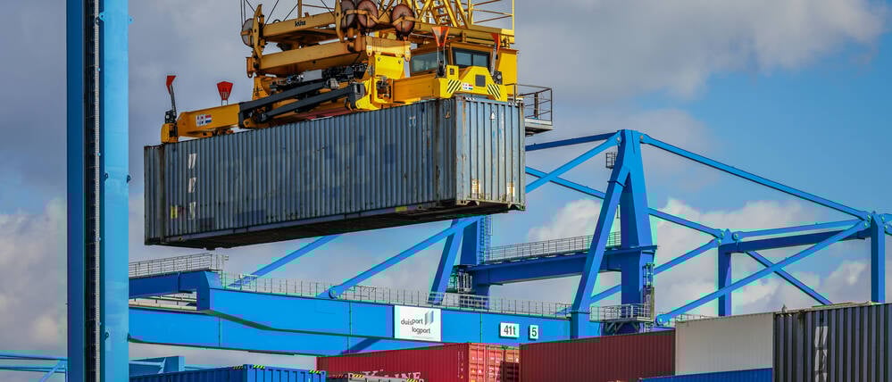 Container im Duisburger Hafen werden auf einen Gueterzug verladen.