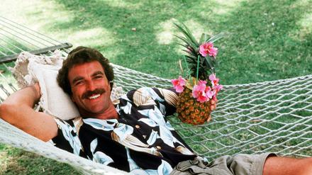 Tom Selleck in seiner Rolle als Magnum entspannt in einer Hängematte.