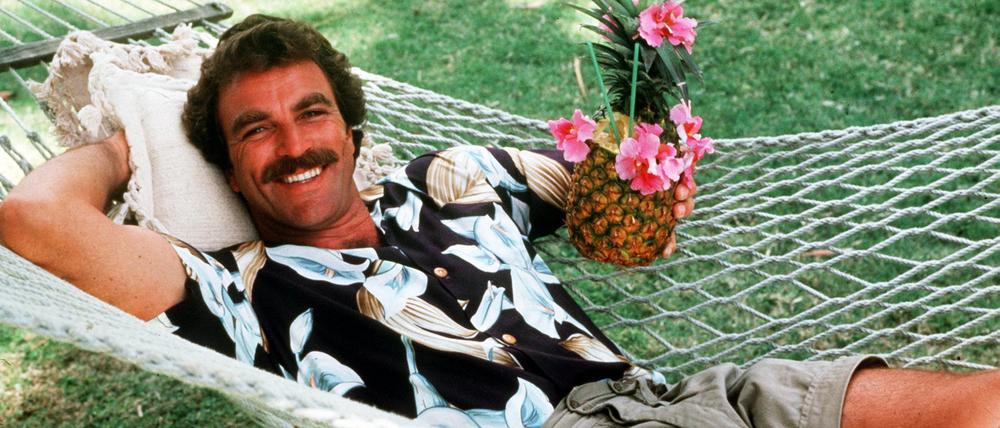 Tom Selleck in seiner Rolle als Magnum entspannt in einer Hängematte.