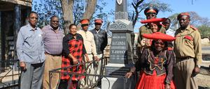 Angehörige der namibischen Volksgruppe der Herero stehen, teils in traditioneller Stammestracht, in der namibischen Stadt Okahandja am Grab eines verstorbenen Oberhäuptlings.