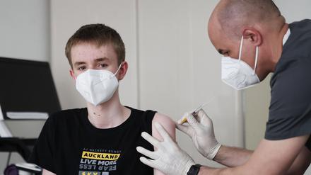 Ein Junge wird in einer Arztpraxis geimpft.