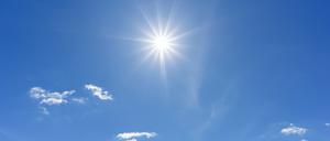 Blue sky with clouds and sun reflection. looking up view