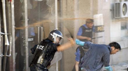 Polizisten und ein Demonstrant vor der Zentrale der Regierungspartei