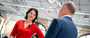 Annalena Baerbock, Kanzlerkandidatin und Bundesvorsitzende von Bündnis 90/Die Grünen, und Olaf Scholz (SPD), SPD-Kanzlerkandidat und Bundesminister der Finanzen, stehen zu Beginn einer Gesprächsrunde des Bundesverbands der Energie- und Wasserwirtschaft zum Thema Energie- und Klimapolitik zusammen. 