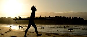 Surfer genießen den Sonnenaufgang am Bondi Beach.