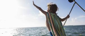 Zugewandt. Ein kleiner Junge lehnt sich aus dem Boote heraus der Sonne entgegen. Gesehen auf Grand Cayman Island. 