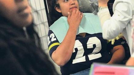 Zähne zeigen. Eine Zahnärztin mit ihrer Patientin bei einem kostenlosen Check. Millionen US-Amerikaner haben bislang noch keine Krankenversicherung. Foto: dpa