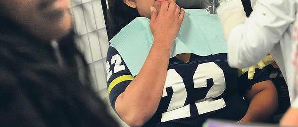 Zähne zeigen. Eine Zahnärztin mit ihrer Patientin bei einem kostenlosen Check. Millionen US-Amerikaner haben bislang noch keine Krankenversicherung. Foto: dpa