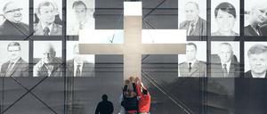 Gedenken. Vor Fotos der Absturzopfer wird in Warschau ein Kreuz aufgerichtet. Foto: AFP