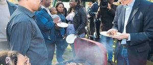 Vorbildlich. Bezirksstadtrat Spallek (r.) isst ordnungsgemäß Gegrilltes. Foto: Uwe Steinert