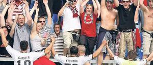 Party mit Fremden. Die Fans des 1. FC Kaiserslautern feiern den Aufstieg in Frankfurt mit der Mannschaft des FSV, die dem FC Augsburg ein Unentschieden abtrotzte. Foto: dpa