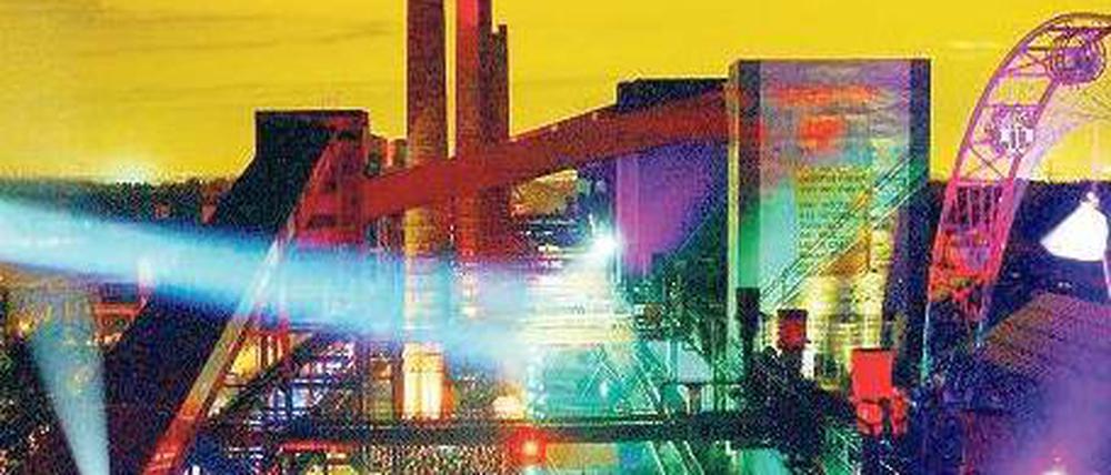 Mythos Ruhrgebiet. Essen wird dieses Jahr als europäische Kulturhauptstadt gefeiert. Als einer der Veranstaltungsorte dient die – hier bunt beleuchtete – Zeche Zollverein. Bis 1986 wurde dort noch Kohle abgebaut.