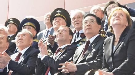 Die da oben. Angela Merkel, Chinas Staatschef Hu Jintau und Russlands Präsident Dmitri Medwedew beobachten während der Parade Fliegerformationen der russischen Luftwaffe.