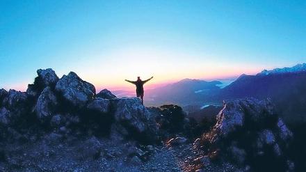 Freiheit am Gipfel in den Ammergauer Alpen frümorgens bei Sonnenaufgang. Foto: dpa